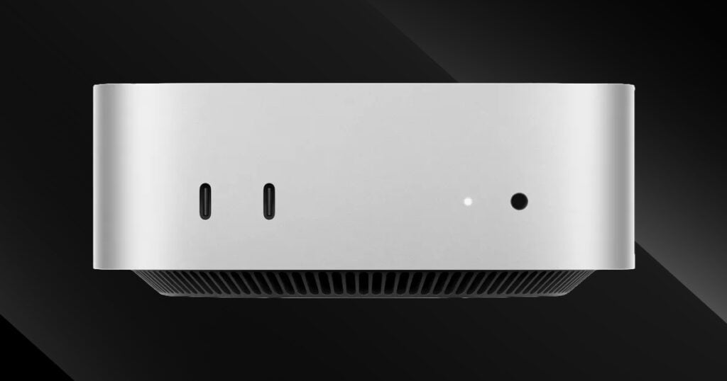 Front view of Apple Mac mini with dual USB-C ports and headphone jack against a dark background