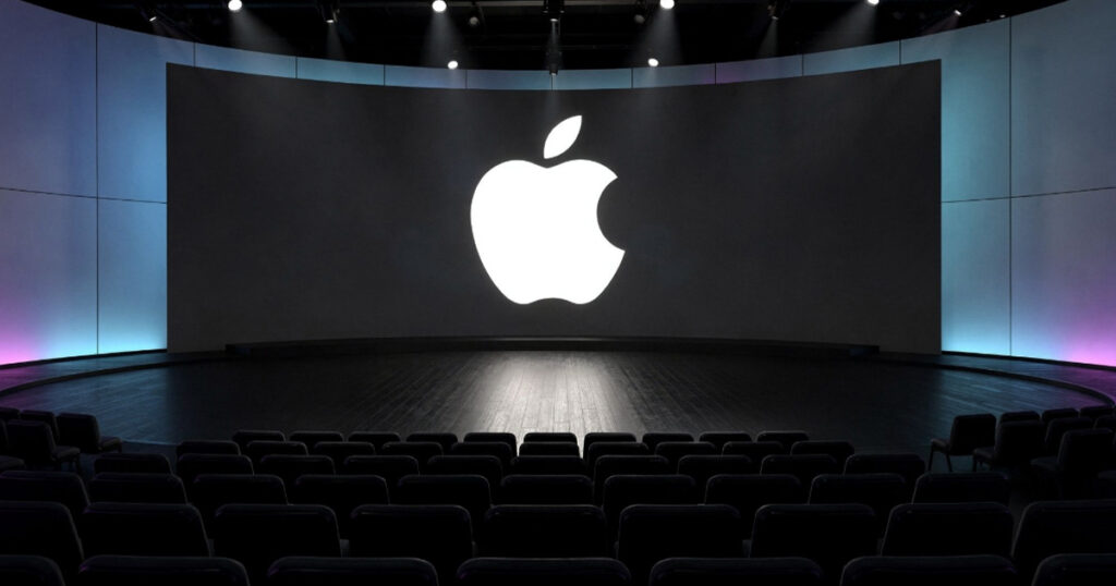 Apple logo displayed on large stage screen inside auditorium ahead of product launch event