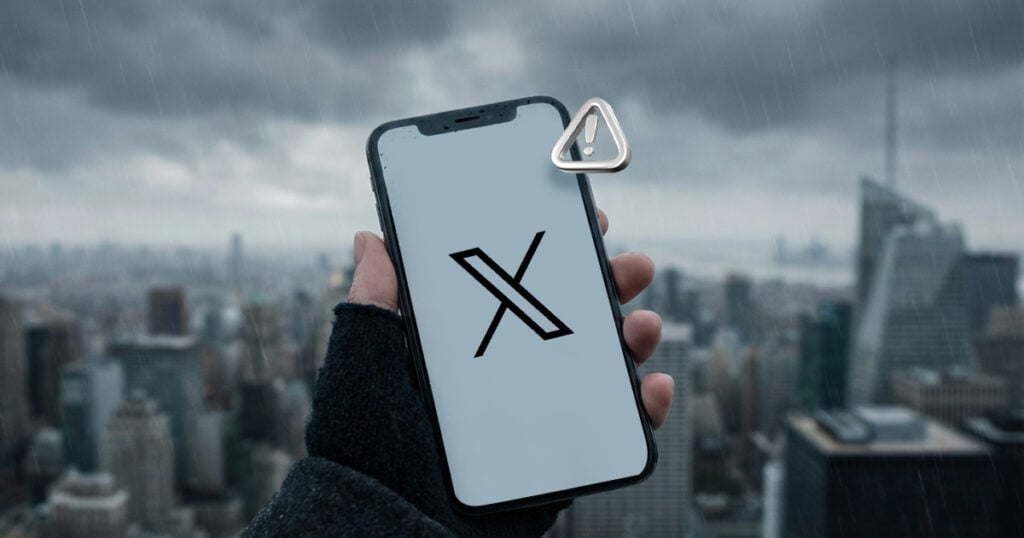 Hand holding a smartphone displaying the X logo with a warning icon over a rainy city skyline